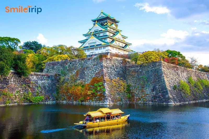 Khung cảnh về đêm tại khu vực Dotonbori, Osaka với các bảng hiệu rực rỡ và thuyền trên kênh