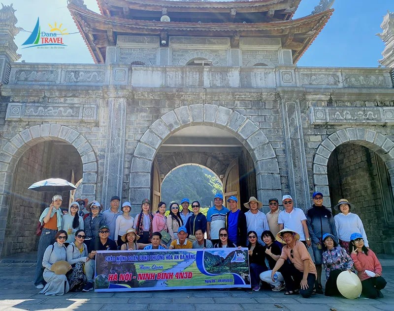 Đoàn khách chụp ảnh trước khu du lịch Tràng An Ninh Bình