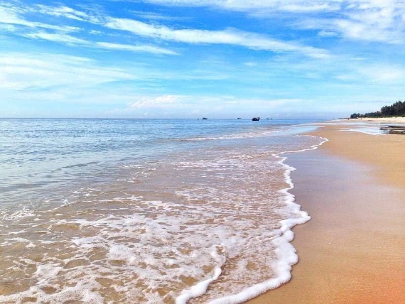 Cảnh biển với những con sóng lăn tăn vỗ vào bờ cát