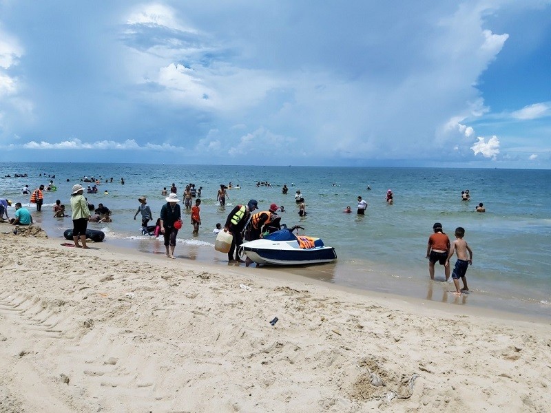 Bãi biển với hàng dương xanh mát và thảm hoa vàng rực rỡ